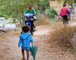 Little girl trying to catch up with her mom and brother.