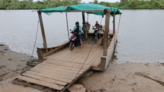 Rick getting ready to ride our scooter off the local river ferry. Kampot, Cambodia.