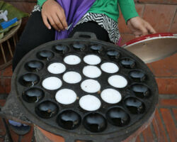 Close-up of coconut pancake batter cooking in the cast iron skillet. You get 10 pieces for less than $1 US. Super delicious. Luang Prabang, Laos.