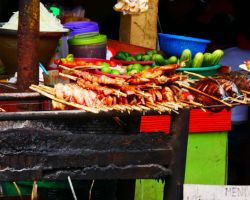 Close-up of meat and fish on BBQ at Kuang Si waterfall. Luang Prabang, Laos.