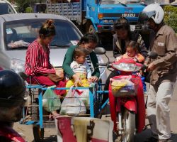 Laos family moto with side-car. We watched all six of them (with bags of groceries) hop in and drive off. There appears to be no load limit on any vehicle over here. Pakse, Laos.