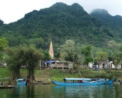 Large Catholic church steeple in the middle of a small Son River village. Phong Nha, Vietnam.