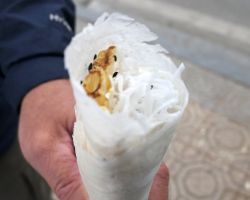 Close-up of a Bo Bia. This rice pancake with honeycomb, fresh shredded coconut, and black sesame seeds rolled inside. So Good. Hanoi, Vietnam.