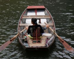 Local tour boat operator (the majority are women and they row with their feet). Tam Coc, Vietnam.