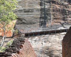 Stairs leading up to another level of the "Lion Rock". You can also see one of the visitor walkways bolted to the side of the rock. Sigiriya, Sri Lanka.