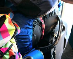 Several pieces of luggage stacked in the doorway of the very crowded train. Galle Fort, Sri Lanka.