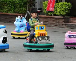 Local kid riding on a small car. Greater Taipei, Taiwan.